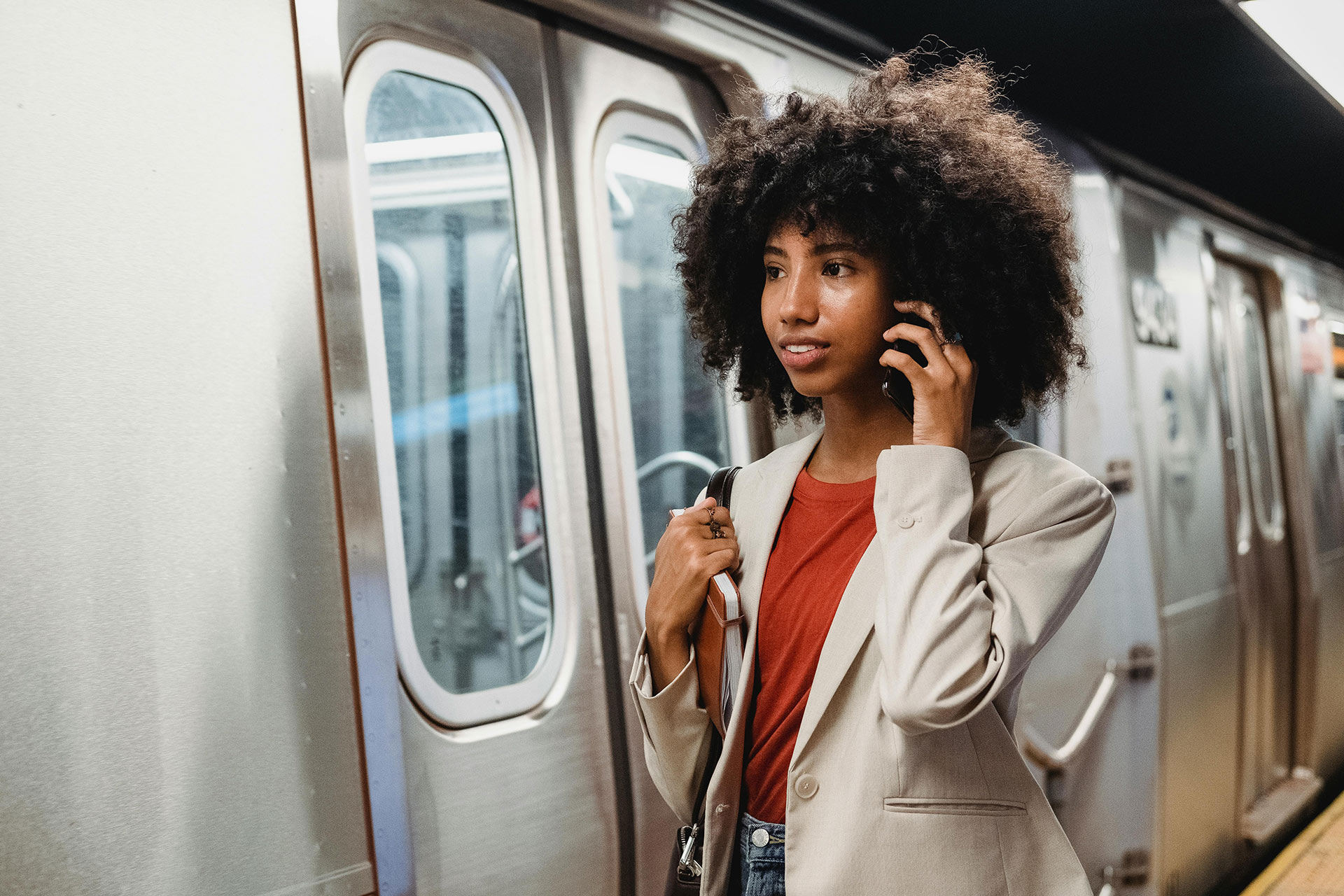 Woman talking on phone while getting on train