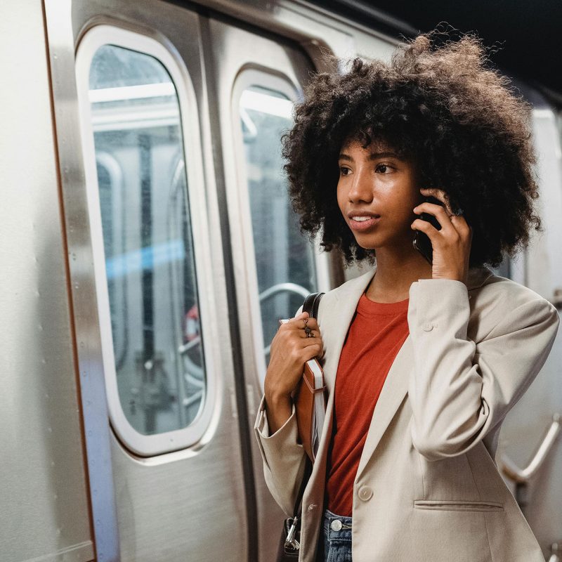 Woman talking on phone while getting on train